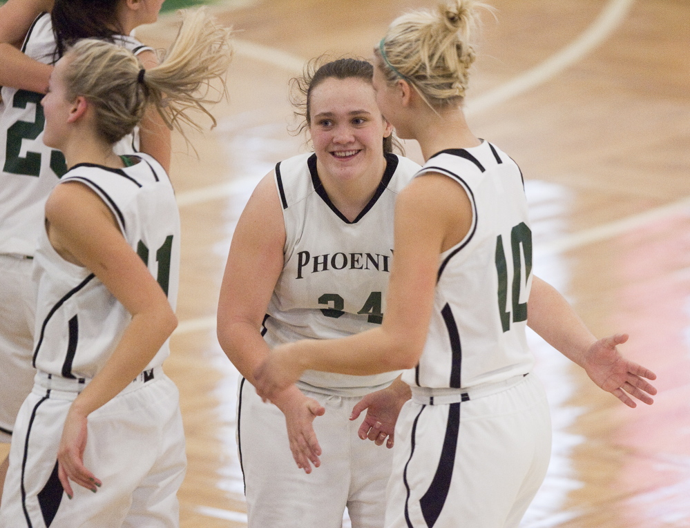 Spruce Mountain’s Emily Keene, center, celebrates with teammate Victoria Ouellette after their team beat Fryeburg Academy 55-51 in a Western Class B girls’ basketball quarterfinal Wednesday at the Portland Expo.