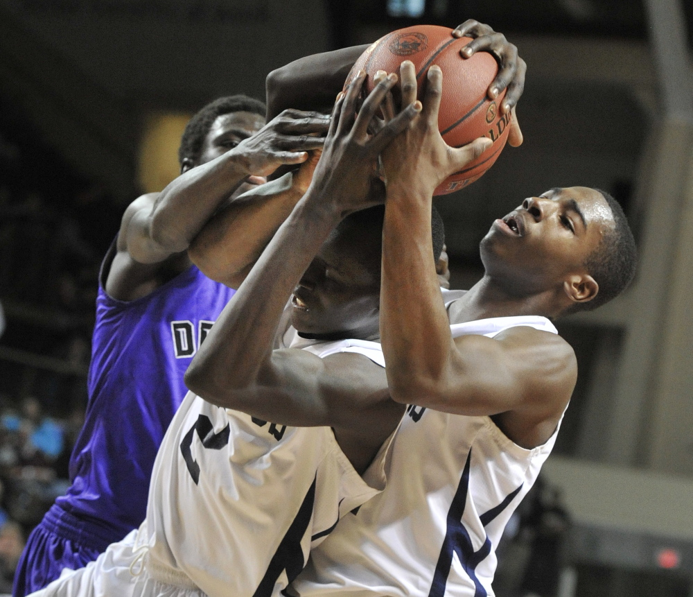 Portland’s Jayvon Pitts-Young, right, battles teammate Stephen Alex and Deering’s Patrick Lobor for a rebound Wednesday night during their Western Class A boys’ basketball semifinal at the Cumberland County Civic Center. Portland kept its unbeaten record intact, winning 64-49.