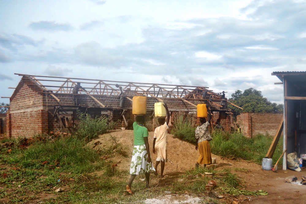 Volunteers carry water to be used in building the Nylo Hope Primary School in South Sudan in this undated photo. The Portland-based non-profit group Aserala is raising funds for the school construction. About 350 students are now studying in the school, which is half complete.