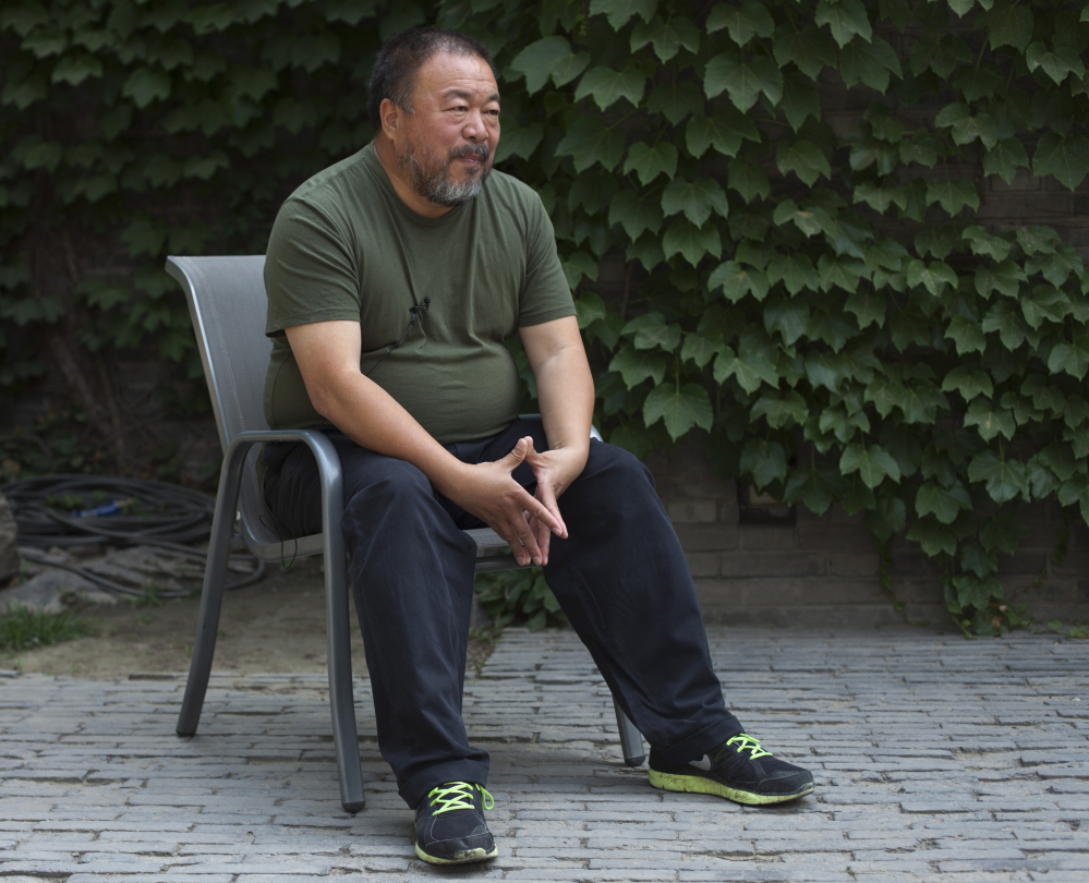 FILE - In this May 22, 2013 file photo, artist Ai Weiwei speaks to journalists at the courtyard of his studio in Beijing. Ai, who helped make his name smashing a valuable vase in the name of art, said Wednesday, Feb. 19, 2014 that he was miffed about another artist destroying one of his vases in Florida. Maximo Caminero was charged with criminal mischief after destroying a vase valued at $1 million that was part of Ai's exhibit at the Perez Art Museum Miami. The Florida artist said he smashed the vase Sunday, Feb. 16 to protest the institution's lack of displays of local artists. Ai said Wednesday that he did not agree with Caminero's tactic. (AP Photo/Alexander F. Yuan, File)