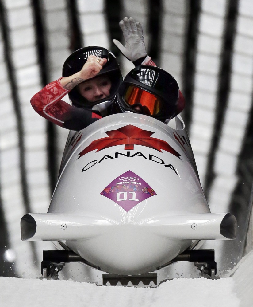The team from Canada CAN-1, piloted Kaillie Humphries with brakeman Heather Moyse, cross into the finish area to win the gold medal in the women's bobsled competition at the 2014 Winter Olympics, Wednesday, Feb. 19, 2014, in Krasnaya Polyana, Russia. (AP Photo/Michael Sohn)