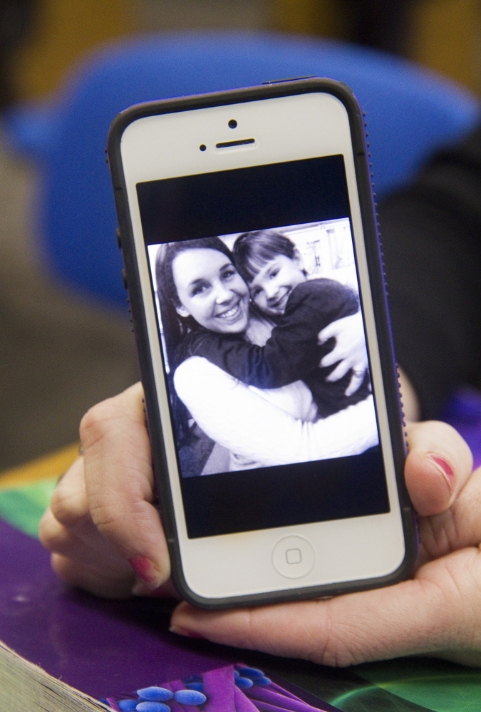 Voucher-user Ellie Fleming holds her phone with a photo of Fleming and her son Gavin, age 4, on Thursday.