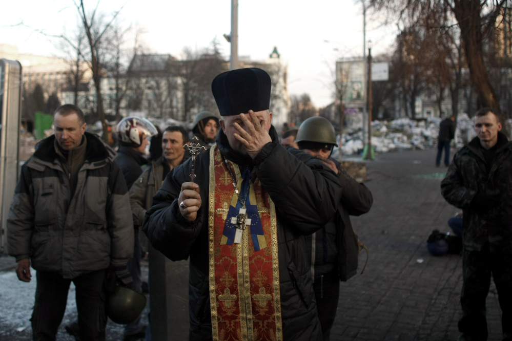 A priest is overcome with emotions as he holds a memorial service for protesters killed during clashes with the police, in Independence Square in Kiev, Ukraine, on Friday.