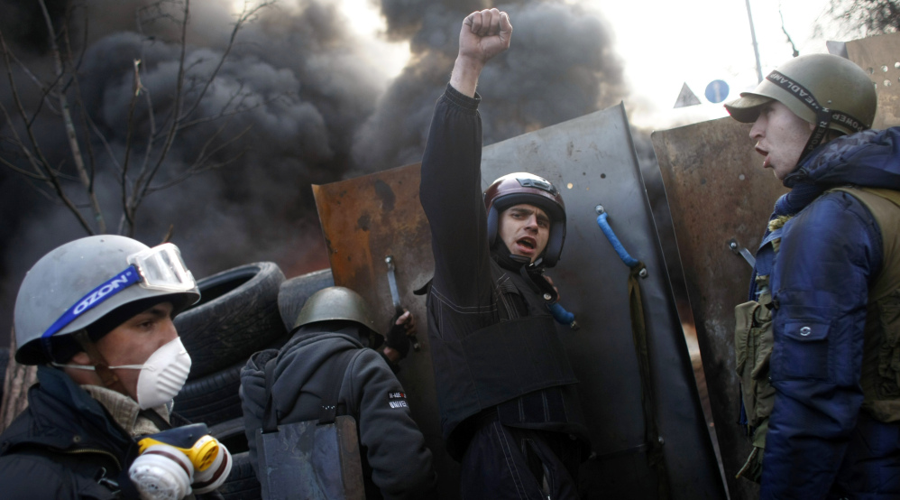 Protesters shout “Glory to the Ukraine” as they man a barricade at Independence Square in Kiev, Ukraine, on Friday.