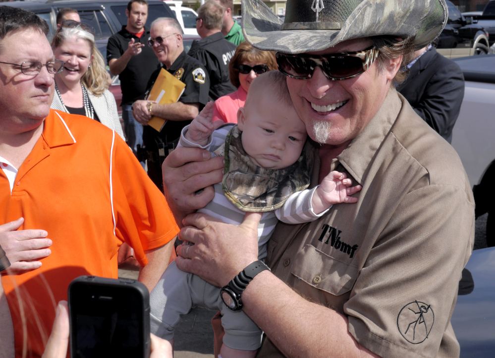 Three-month-old James Bodiford of Lavon, Texas, is photographed with rocker Ted Nugent as he visits with fans during a stop at a local restaurant Tuesday in Denton, Texas.