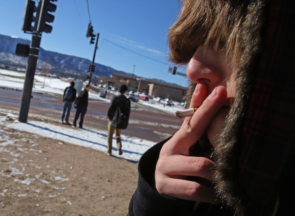 A high school student, who preferred not to be identified, smokes a cigarette in a de facto smoking area just off the property of Lewis-Palmer High School, in Monument, Colo., on Thursday. Colorado already has one of the nation’s lowest smoking rates, about 18 percent in 2011, according to the CDC.