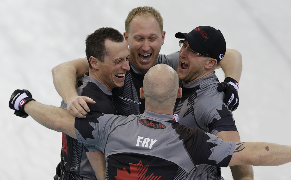Canada’s men’s curling team as seen clockwise, Brad Jacobs, Ryan Harnden, Ryan Fry and E.J. Harnden celebrate after beating Britain to win the men’s curling gold medal game.