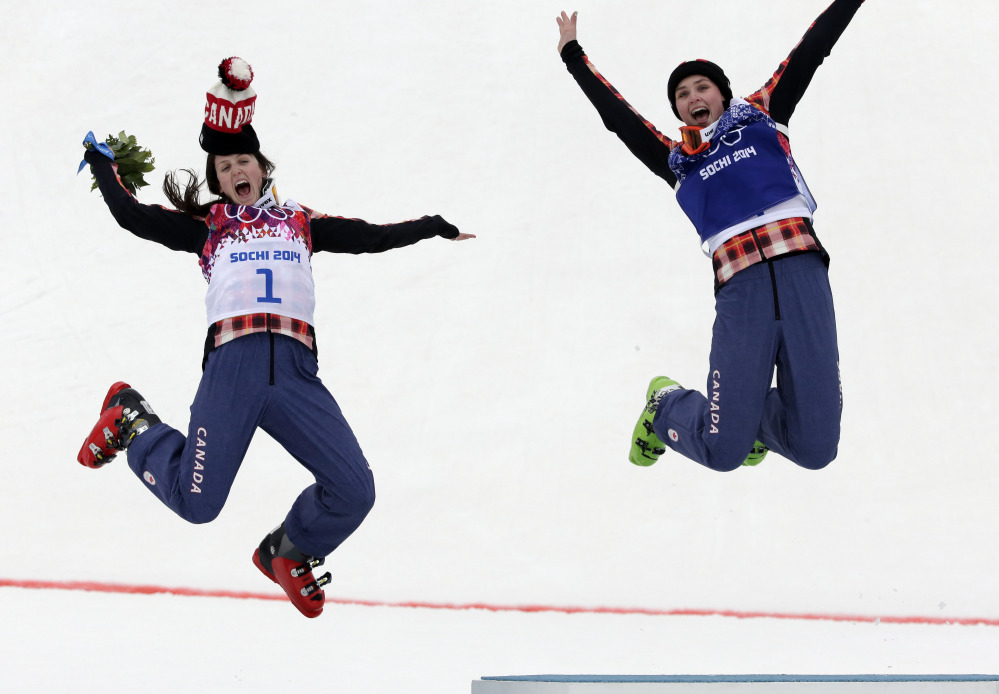 Women’s ski cross gold medalist Marielle Thompson of Canada, right, celebrates Friday on the podium with silver medalist and compatriot Kelsey Serwa at the 2014 Winter Olympics in Krasnaya Polyana, Russia.