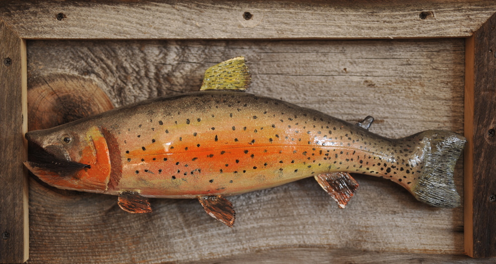 One of the pieces of art and memorabilia on the walls of Smith's office is a replica of a trout carved by his father.