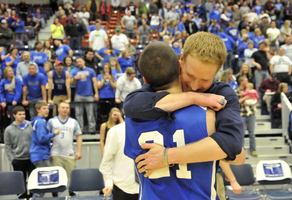 Valley assistant coach Jason Hartwell embraces Collin Miller after the Cavaliers rallied for a 50-49 win over Hyde in the Western Class D boys’ basketball championship game Saturday at the Augusta Civic Center.