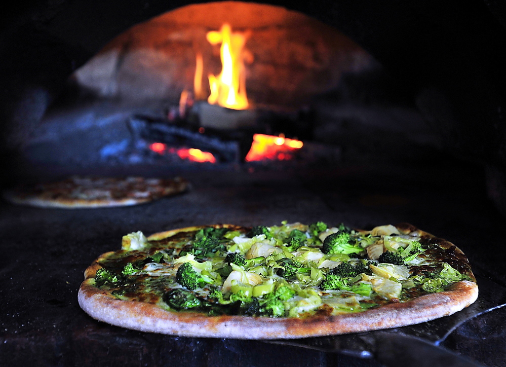 This Evergreenza pizza is ready to come out of the woodfired brick oven at Siano's Pizzeria. Ingredients include pesto, spinach artichokes, pepperoncinis & broccoli.