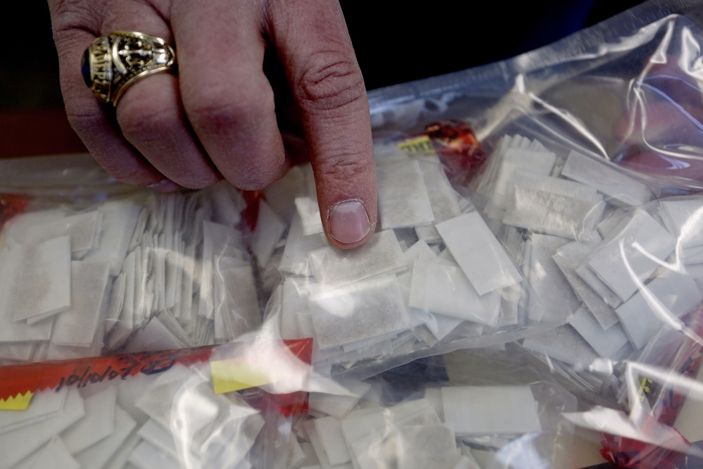 Cmdr. Scott Pelletier, head of the Maine Drug Enforcement Agency in southern Maine, points out heroin packets that were seized in the state.