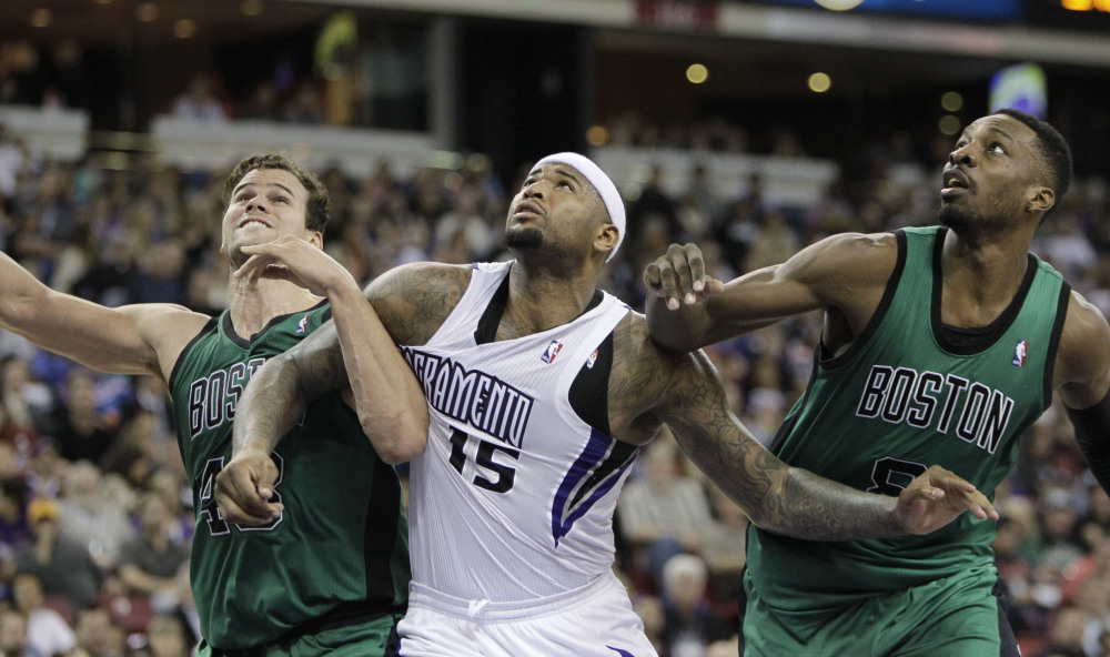 Sacramento Kings center DeMarcus Cousins battles for rebounding position with Boston Celtics’ Kris Humphries, left, and Jeff Green in the fourth quarter Saturday in Sacramento, Calif.