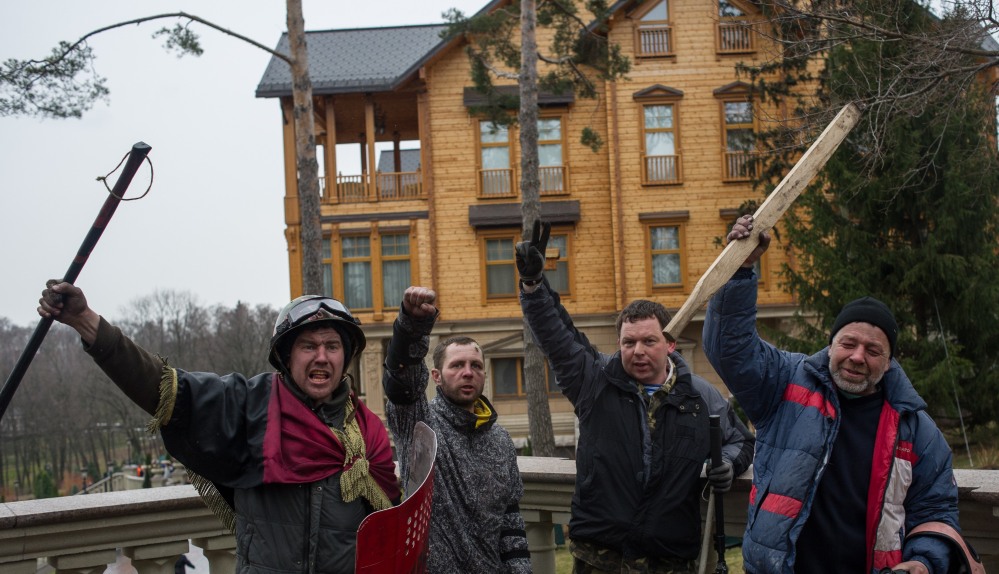 Protesters pose in front of the Ukrainian President Yanukovych’s countryside residence in Mezhyhirya, Kiev’s region, Ukraine, Saturday. Ukrainian security and volunteers from among Independence Square protesters have joined forces to protect the presidential countryside retreat from vandalism and looting.