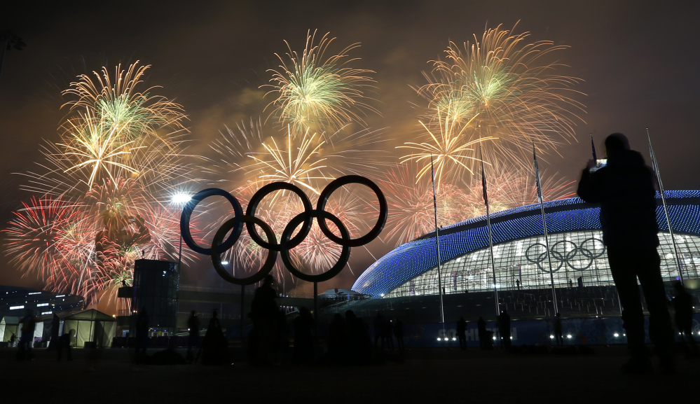 A man takes a photograph of fireworks during the closing ceremony of the 2014 Winter Olympics on Sunday.
