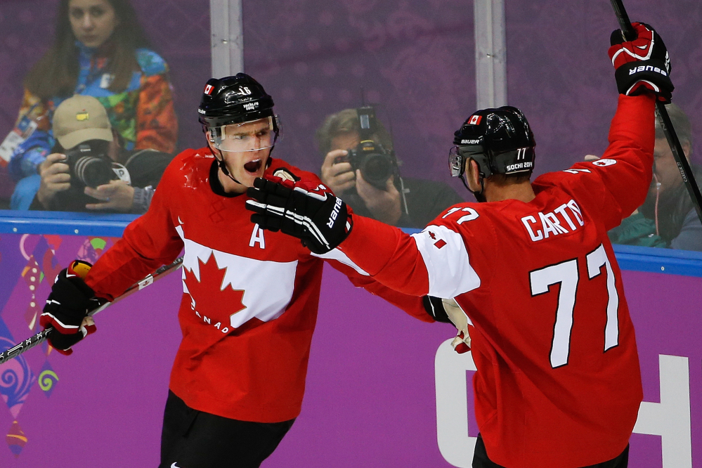 Jonathan Toews of Canada celebrates his goal with teammate Jeff Carter during the first period of the men’s gold medal hockey game Sunday against Sweden at the 2014 Winter Olympics in Sochi, Russia