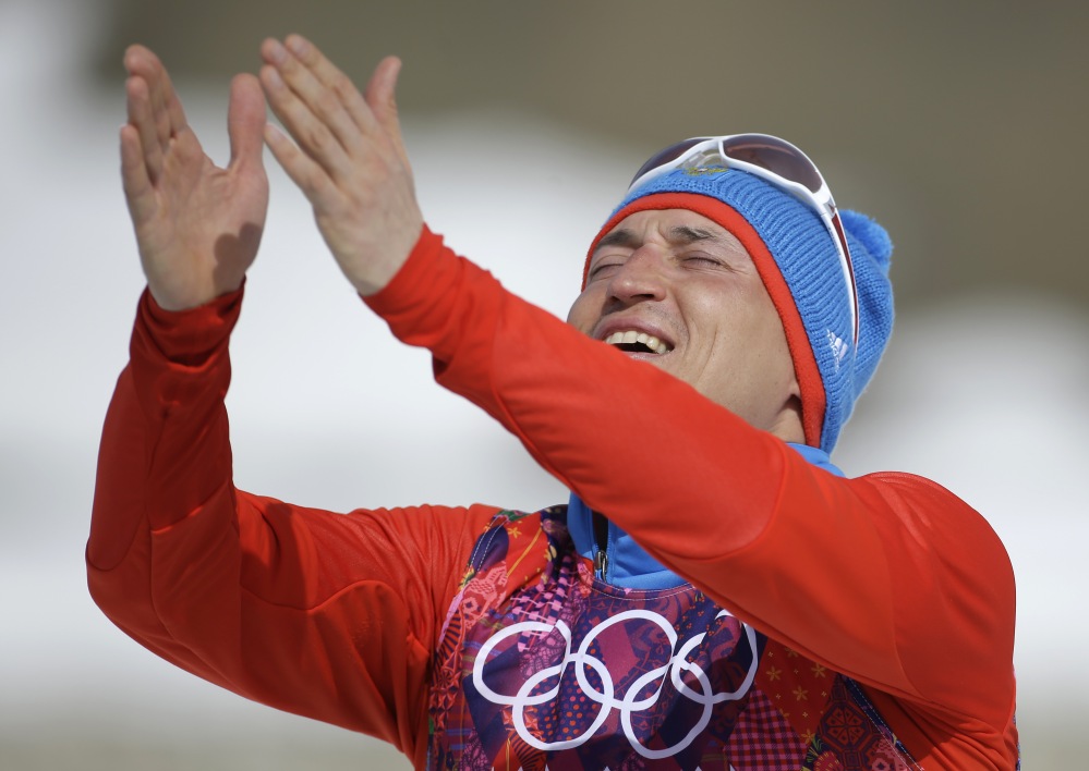 Russia’s gold-medal winner Alexander Legkov gestures to the crowd during the flower ceremony of the men’s 50K cross-country race Sunday at the 2014 Winter Olympics in Krasnaya Polyana, Russia.