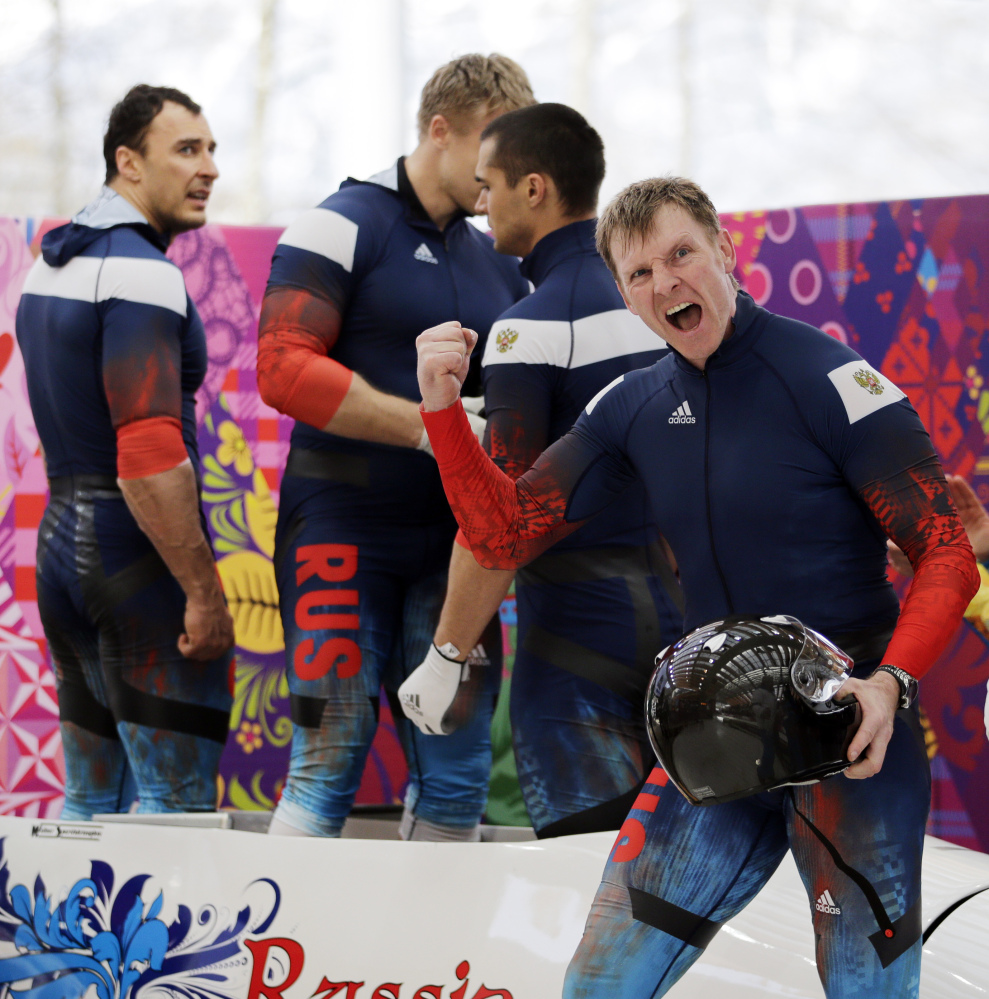 The team from Russia RUS-1, with Alexander Zubkov, foreground, Alexey Negodaylo, Dmitry Trunenkov, and Alexey Voevoda, react after their third run during the men’s four-man bobsled competition final Sunday at the 2014 Winter Olympics in Krasnaya Polyana, Russia.