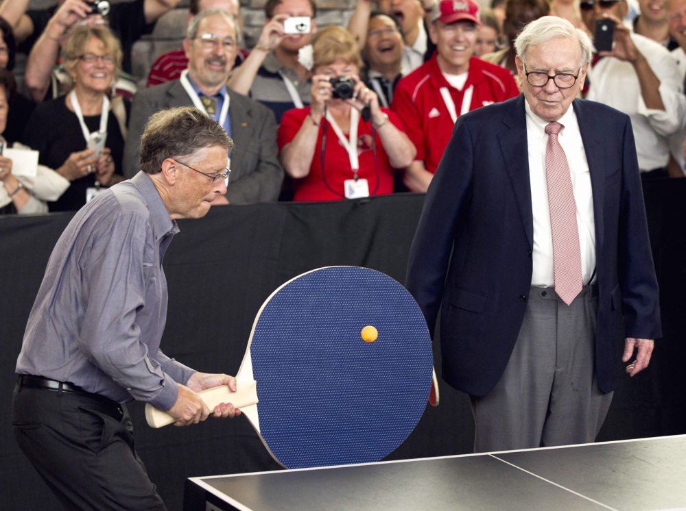 In this May 6, 2012 file photo, Warren Buffett, chairman and CEO of Berkshire Hathaway, right, watches Bill Gates use an oversize paddle as they play doubles against table tennis prodigy Ariel Hsing in Omaha, Neb. Buffet has advocated for a progressive estate tax before members of Congress.