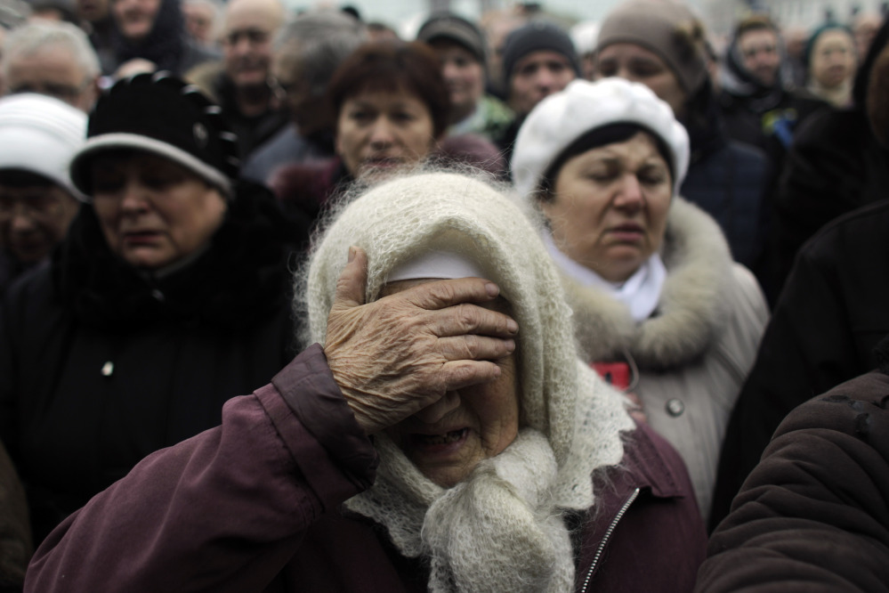 A woman reacts at a memorial for the people killed in clashes with the police at Kiev’s Independence Square, the epicenter of the country’s current unrest, Ukraine, Tuesday, Feb. 25, 2014.