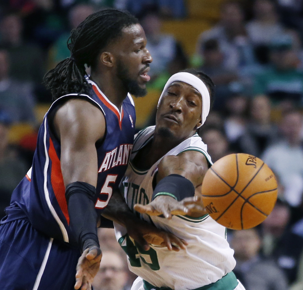 DeMarre Carroll of the Atlanta Hawks passes while being pressured by Gerald Wallace of the Boston Celtics during the first period of Boston’s 115-104 victory Wednesday.