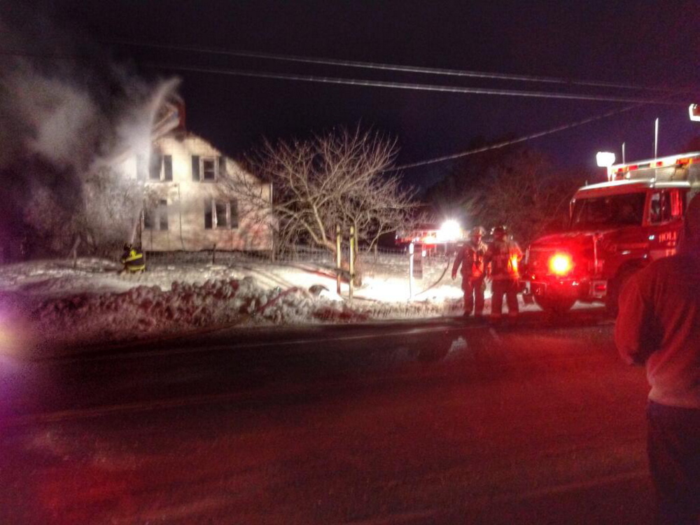 Firefighters from several communities fight a fire at a farmhouse on Route 117 in Hollis on Wednesday.