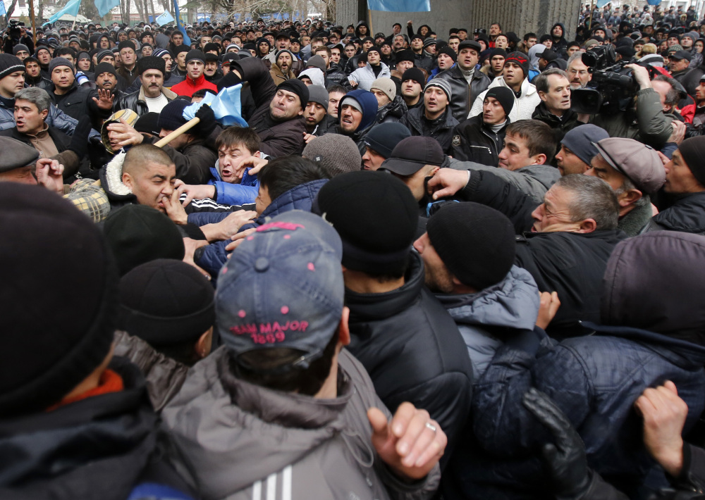 Pro-Russian protesters, right, clash with Crimean Tatars in front of a local government building in Simferopol, Crimea, Ukraine, on Wednesday. More than 10,000 Muslim Tatars rallied in support of the interim government. That group clashed with a smaller pro-Russian rally nearby.