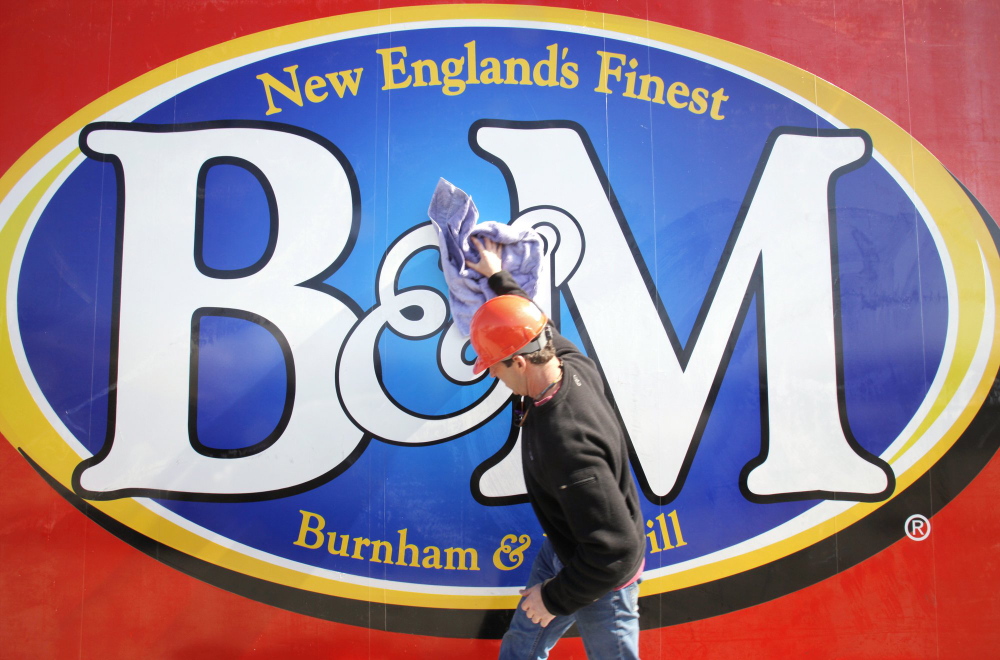 Gregory Rec/Staff Photographer Kyle Noyes, with Sign One of Falmouth, wipes down a new B&M sign before it gets lifted into place at the top of the bean factory in Portland in March 2010.