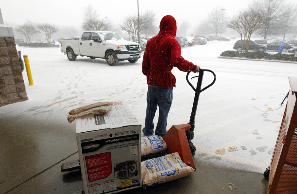 Home Depot employee Chris Craft pulls a generator and some sand to the front of the store for a customer in Cary, N.C., earlier this month. Home Depot Inc. estimated it lost $100 million in January because of weather.