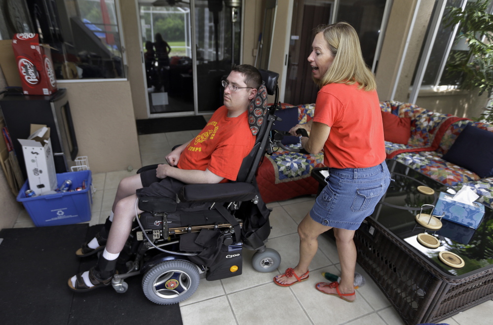 Chris Ott helps her son, former Marine John Thomas Doody, who was shot while serving in Fallujah, Iraq, in Riverview, Fla. More than two dozen veterans’ groups supported legislation rejected in the Senate on Thursday to boost aid to veterans.