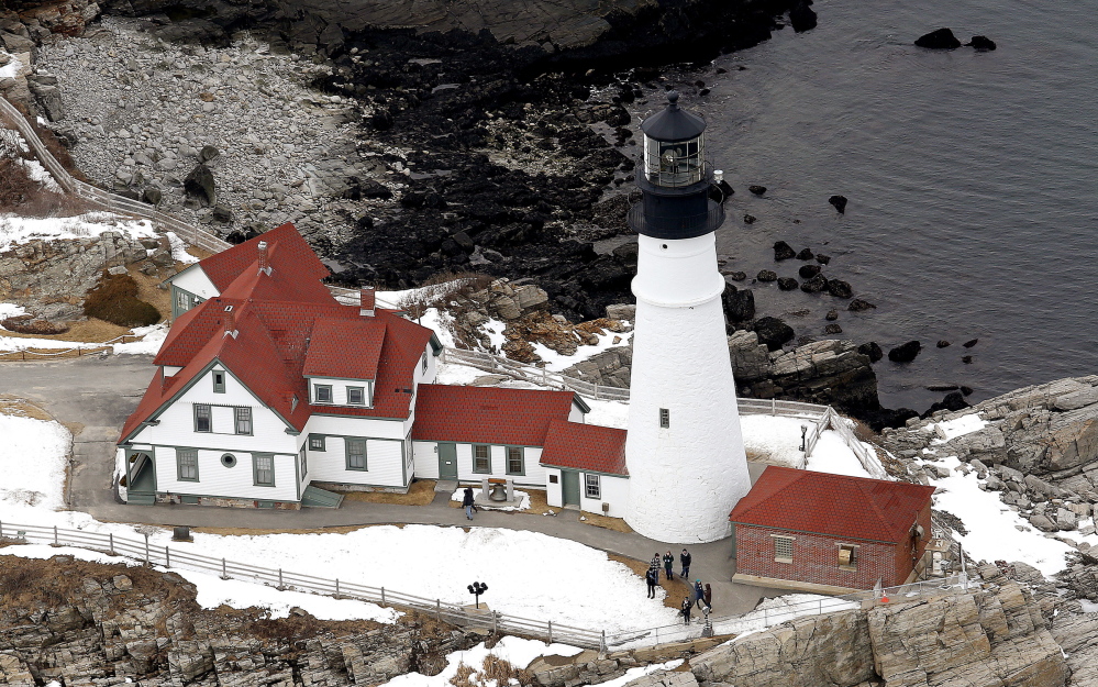 Tourists visit Portland Head Light in Cape Elizabeth on Tuesday. Stone seating is part of an improvement plan at the park.