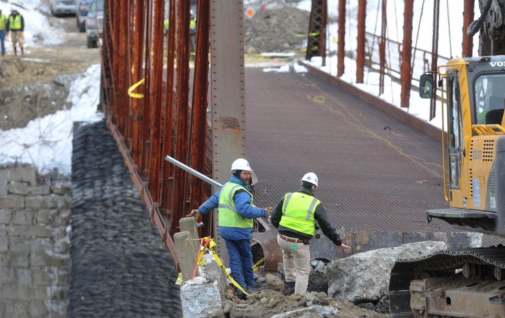 Crews stand by as an excavator jack-hammers the New Sharon bridge on Thursday after the initial controlled explosions failed to bring down the historic structure.