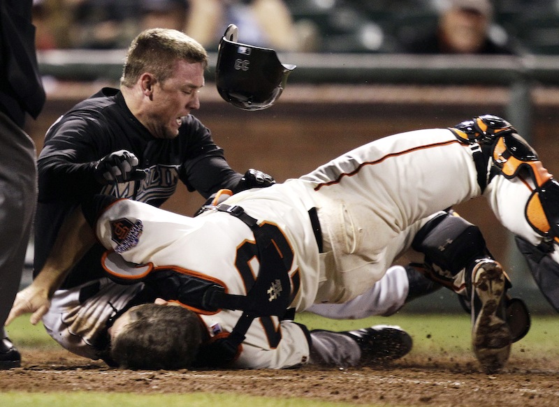 In this May 25, 2011 file photo, Florida Marlins' Scott Cousins, top, collides with San Francisco Giants catcher Buster Posey (28) on a fly ball from Emilio Bonifacio during the 12th inning of a baseball game in San Francisco. Cousins was safe for the go ahead run. A new rule, 7.13, was adopted by MLB and the players' association on a one-year experimental basis, the sides said Monday, Feb. 24, 2014. The umpire crew chief can use the new video-review system to determine whether the rule was violated.