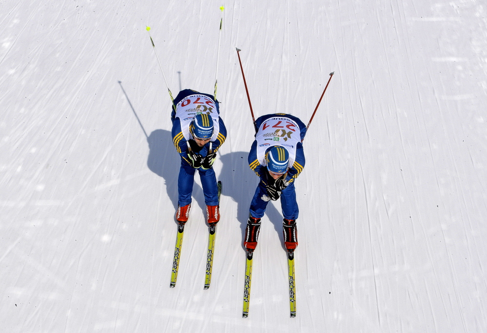 Two Swedish skiers head down a trail at the Nordic Heritage Center in Presque Isle on Friday during a practice run. Athletes from around the world got a cold taste of competing in Maine as the wind chill was at minus-2.
