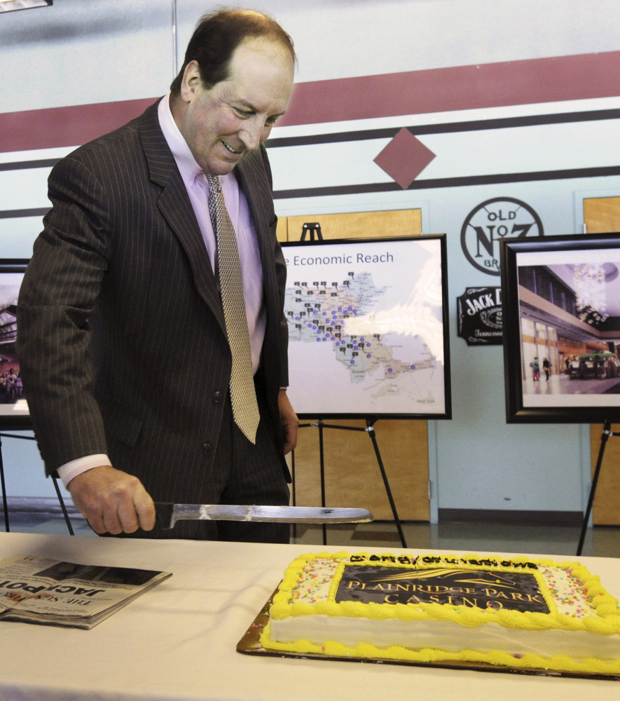 Penn National Gaming President Timothy Wilmott cuts a cake at a party Friday after Massachusetts granted the company a five-year operating license for expanded gambling.
