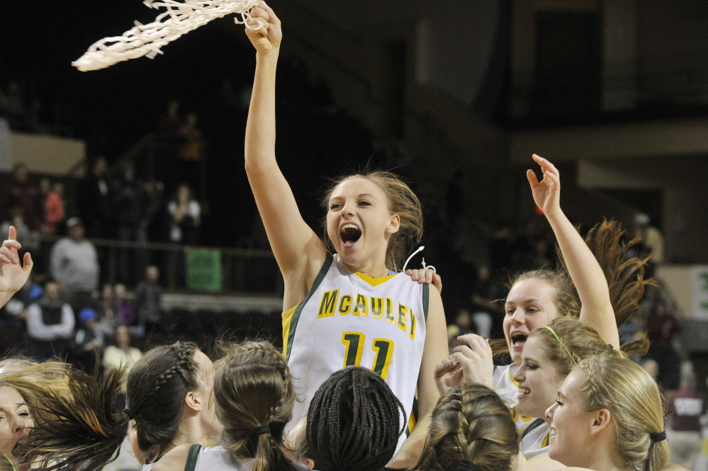 Olivia Smith twirls the net as McAuley players celebrate after beating Oxford Hills 67-41 Saturday afternoon at the Cumberland County Civic Center to win their fourth consecutive Class A girls’ basketball state championship.