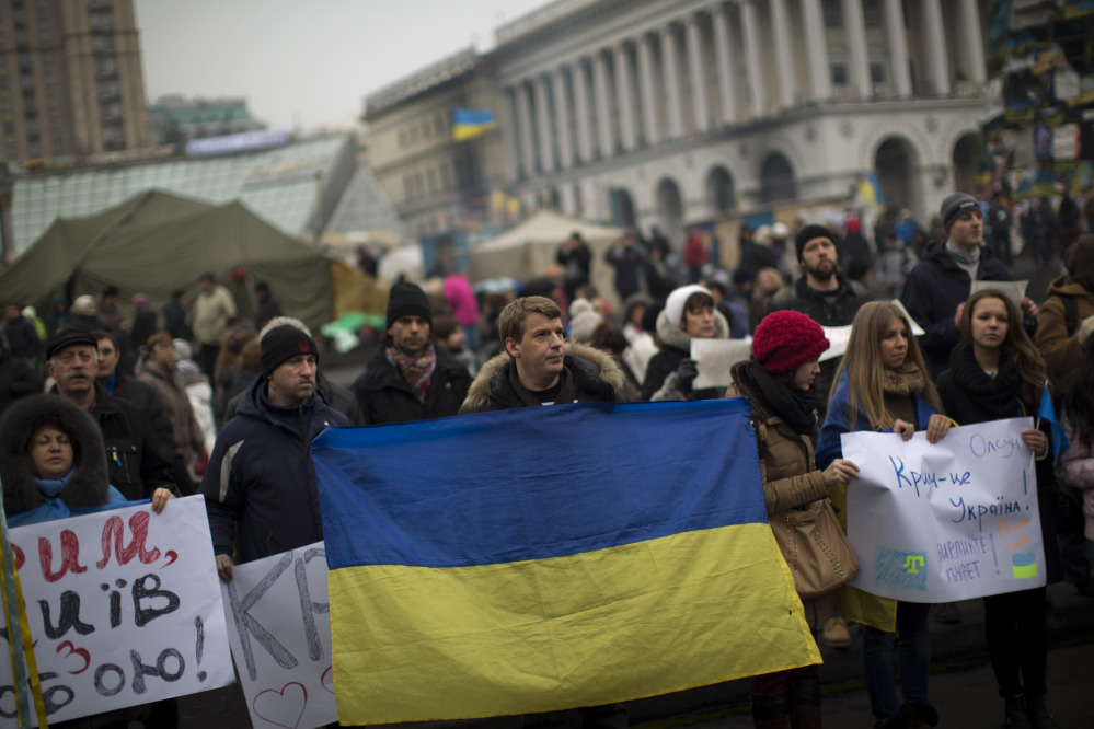 Protesters, one them holding a Ukraine flag, demonstrate against the military intervention of Russia in Crimea as they gather in Kiev’s Independence Square, the epicenter of the country’s current unrest, on Saturday.