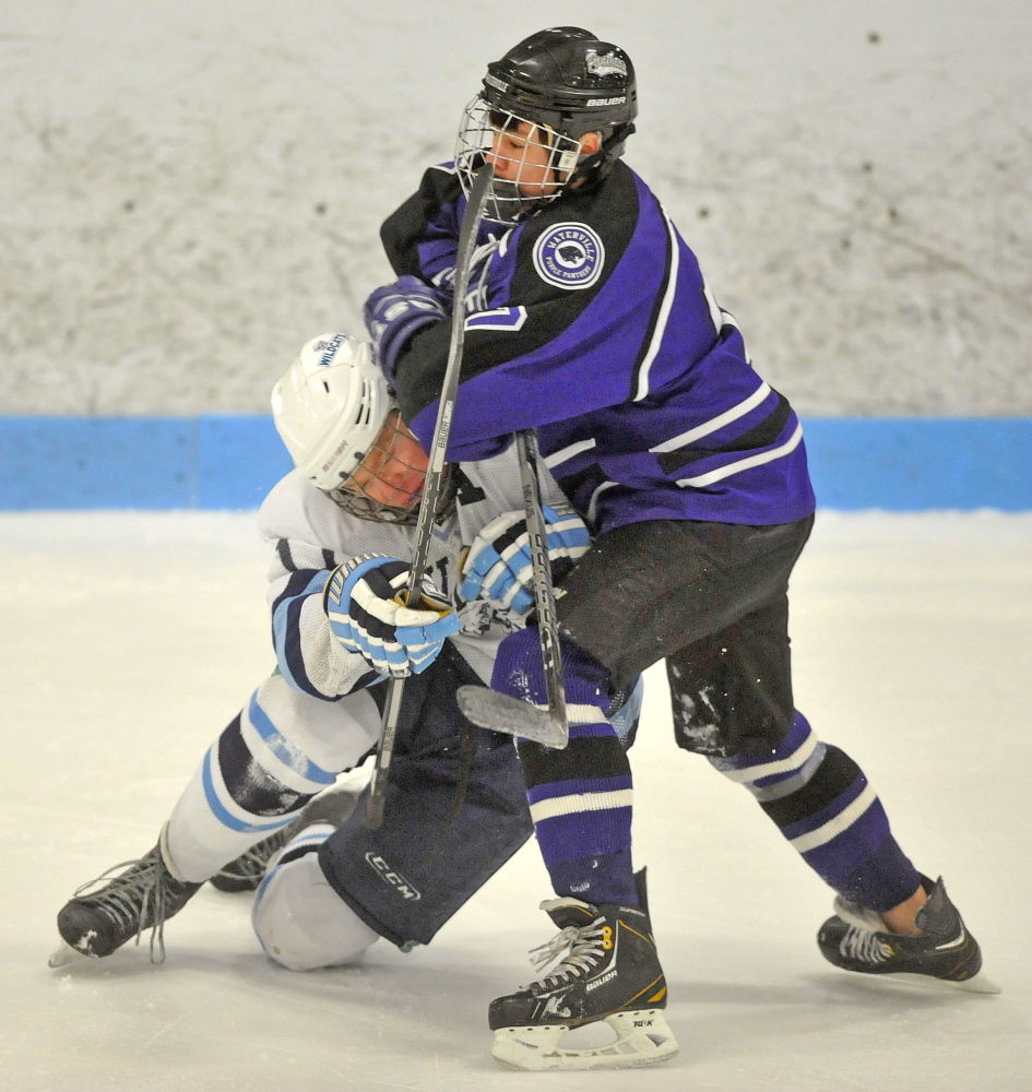 Waterville’s Nick Denis, right, collides with Presque Isle’s Andrew Michaud during an Eastern Class B boys’ hockey semifinal Saturday at Sukee Arena in Winslow. Presque Isle won, 5-4.