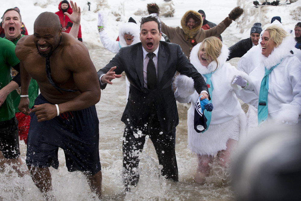 “The Tonight Show” host Jimmy Fallon, center, exits the water during the Chicago Polar Plunge on Sunday in Chicago. Fallon joined Chicago Mayor Rahm Emanuel in the event.