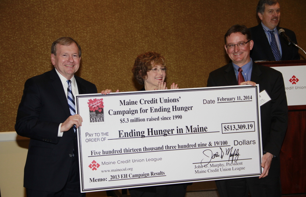 John Murphy, president of the Maine Credit Union League, Sue Mitchell and Luke Labbe, chairman of the league’s Social Responsibility Committee, display a check representing the record amount of $513,309.19 raised through the Maine credit unions’ Campaign for Ending Hunger in 2013.