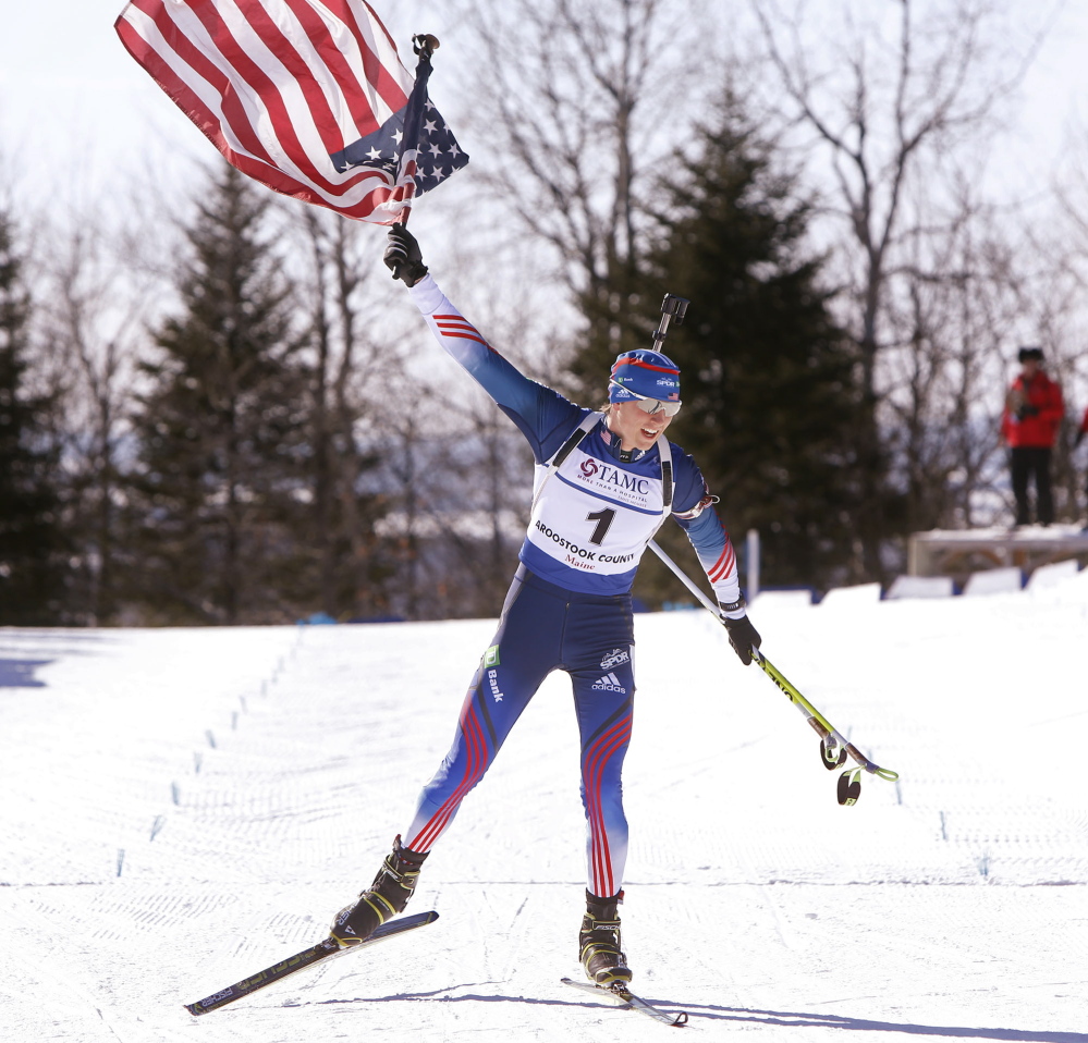 Sean Doherty of Center Conway, N.H., hoists the American flag high as he crosses the finish line to win the youth 10K pursuit Sunday at the IBU Biathlon Youth/Junior World Championships in Presque Isle, earning his second gold medal in three days.