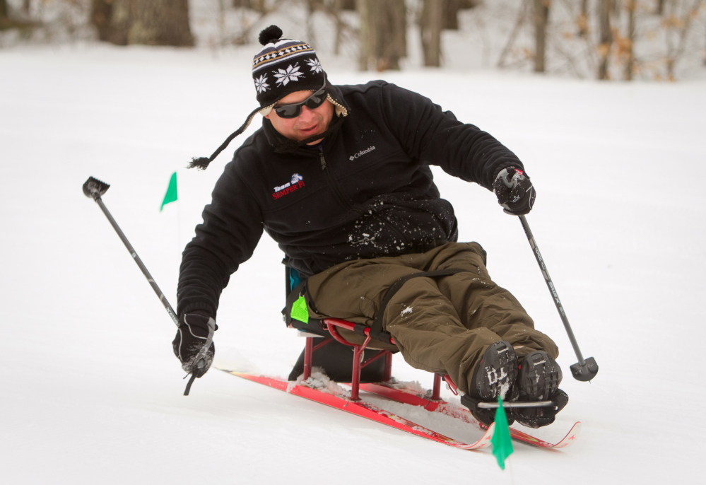 Ernesto Aquino propels himself on a ski sled during a biathlon at Pineland Farms in New Gloucester on Sunday. “This is a great place for me,” Aquino said. “It helps me relax.”