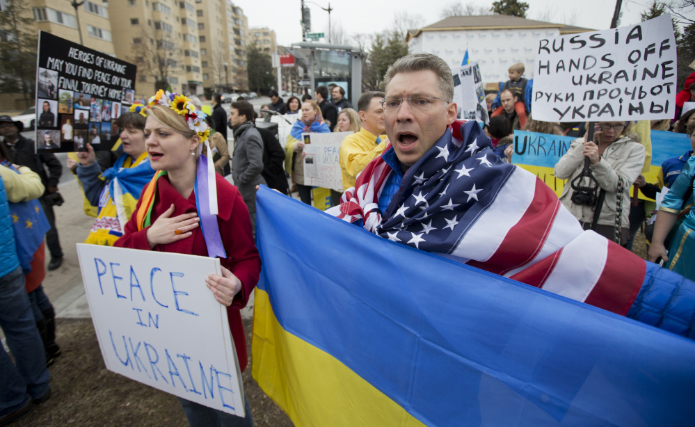 Moscow-born Dmitry Savransky, right, who holds dual citizenship, American and Russian, joins his Ukrainian wife, Natalya Seay, left, during a protest rally in front of the Russian embassy in Washington on Sunday.
