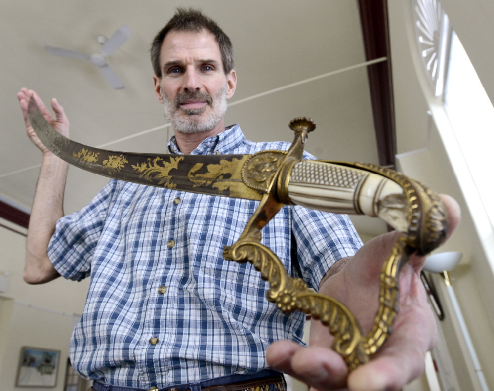Thomas Bennett, director of Prince Memorial Library, displays a sword possibly owned by President Andrew Jackson.