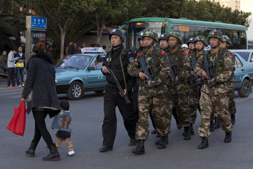 Armed police and paramilitary members patrol a street Monday near the Kunming Railway Station, where knife-wielding attackers slashed scores of people Saturday, leaving 29 dead. Four of the attackers were killed and four suspects have been arrested.