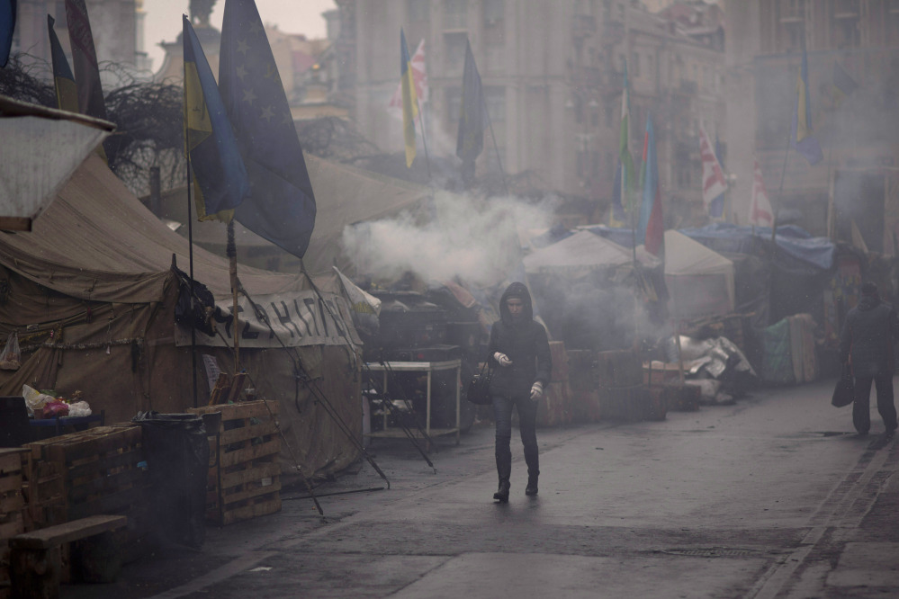 A woman walks past tents erected by protesters who oppose ousted Ukrainian president Viktor Yanukovych, at Kiev’s Independence Square, on Monday.