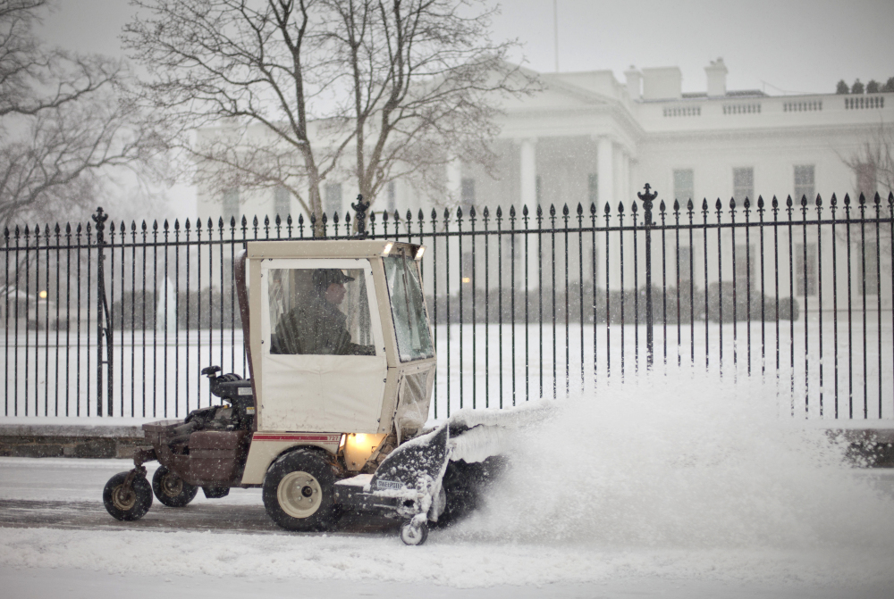 The sidewalk in front of the White House is cleared of snow on Monday. The National Weather Service issued a Winter Storm Warning for the greater Washington Metropolitan region, prompting area schools and the federal government to close.
