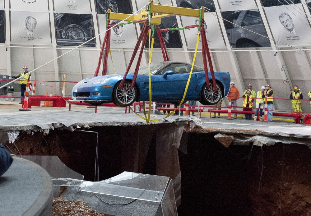 One of eight Chevrolet Corvettes is removed from a sinkhole Monday at the National Corvette Museum in Bowling Green, Ky. On Feb. 12, a sinkhole swallowed eight prized cars, piling them in a heap amid loose dirt and concrete fragments.