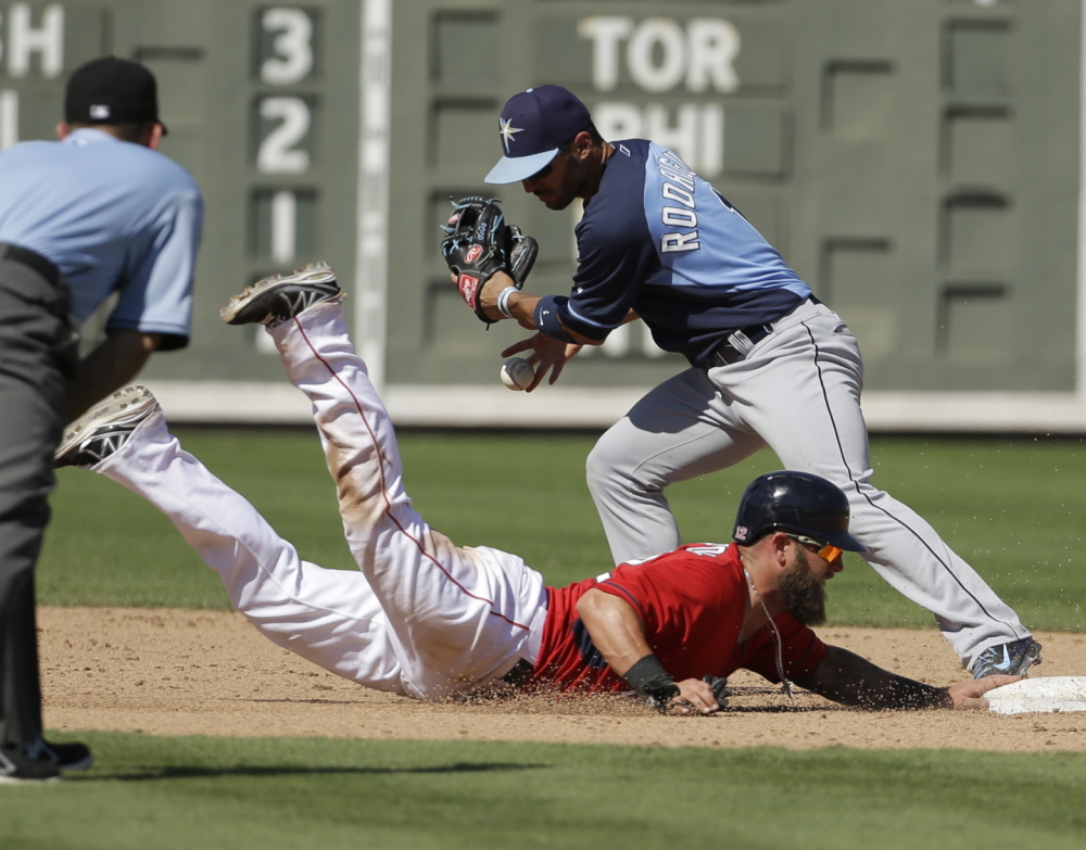 Sean Rodriguez of the Tampa Bay Rays is unable to tag Boston’s Mike Napoli, who returns to second base after Xander Bogaerts grounded out in Tuesday’s exhibition game at Fort Myers, Fla. Tampa Bay won, 8-0.