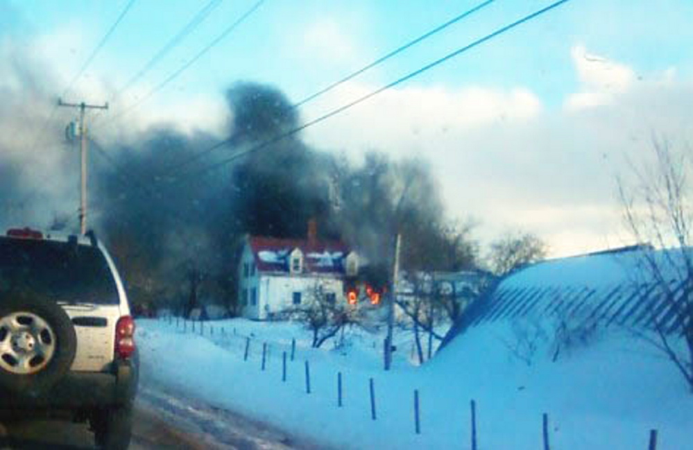 Flames are visible Feb. 26 as a farmhouse in Hollis burns. Three firefighters initially responded to the blaze. A shortage of volunteer firefighters hits hard in Maine, where about 95 percent of fire departments are made up entirely or mostly of volunteers.